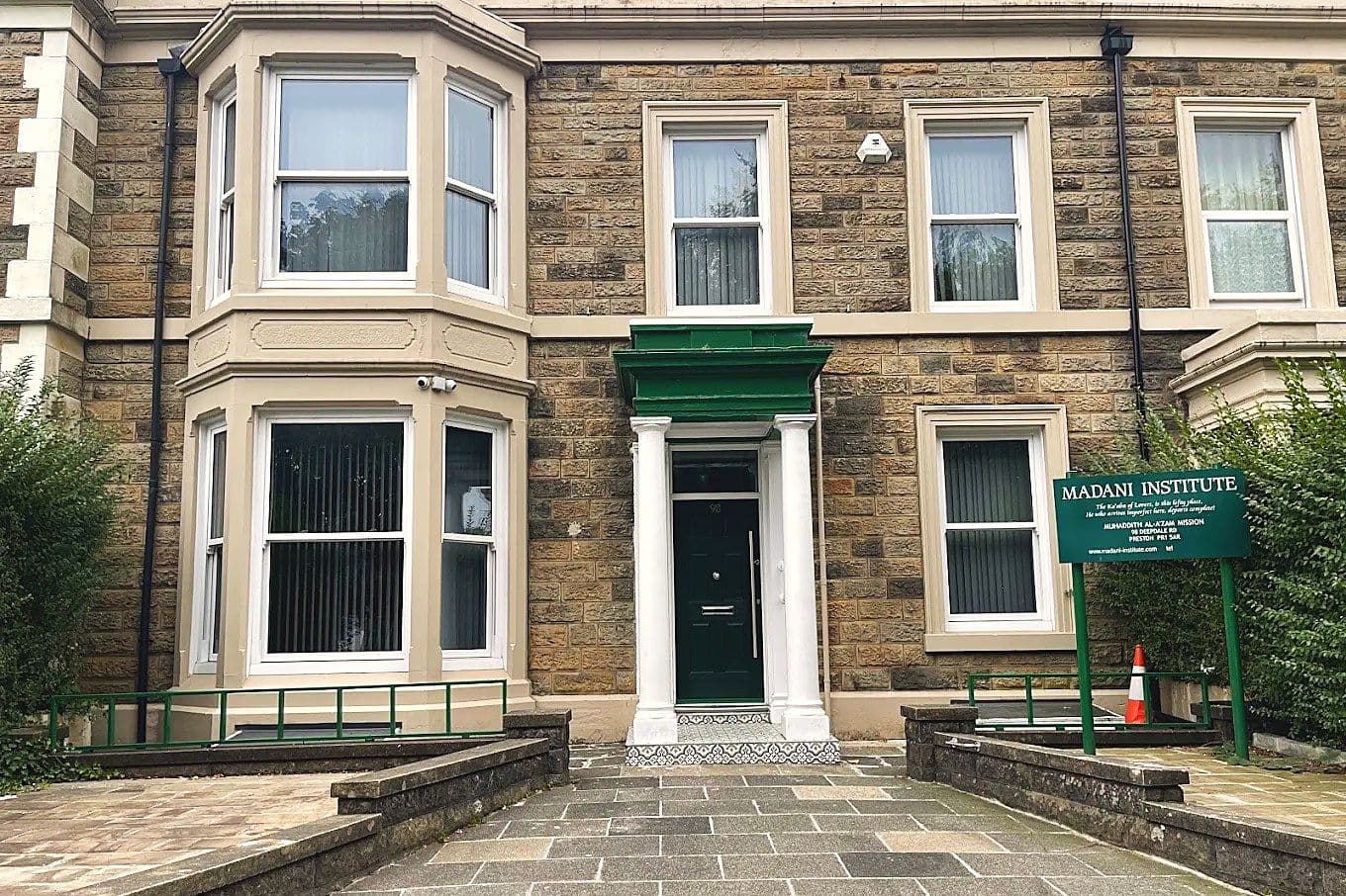 The front of Madani Institute at 98 Deepdale Road, with its pillared porch and the green Madani Institute sign by the path